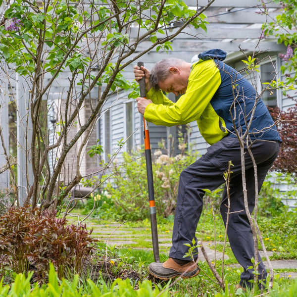Person gardening with a shovel in a backyard setting